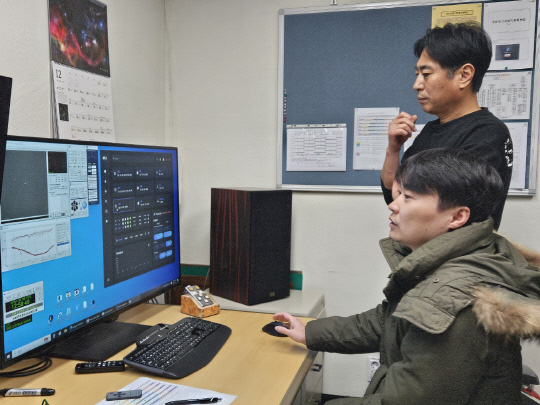 박영식 천문연 소백산천문대장(서 있는 사람)과 한기영 오퍼레이터가 61㎝망원경 관측제어실에서 컴퓨터로 촬영한 천체 데이터를 살펴보고 있다.